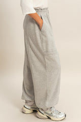 woman wearing gray wide-leg sweatpants with side pockets and an elastic waistband