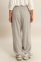 woman wearing gray sweatpants with a relaxed fit and cargo pockets, shown from the back