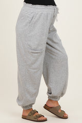 woman wearing gray maternity jogger pants with side pockets and cuffed ankles, styled with brown sandals