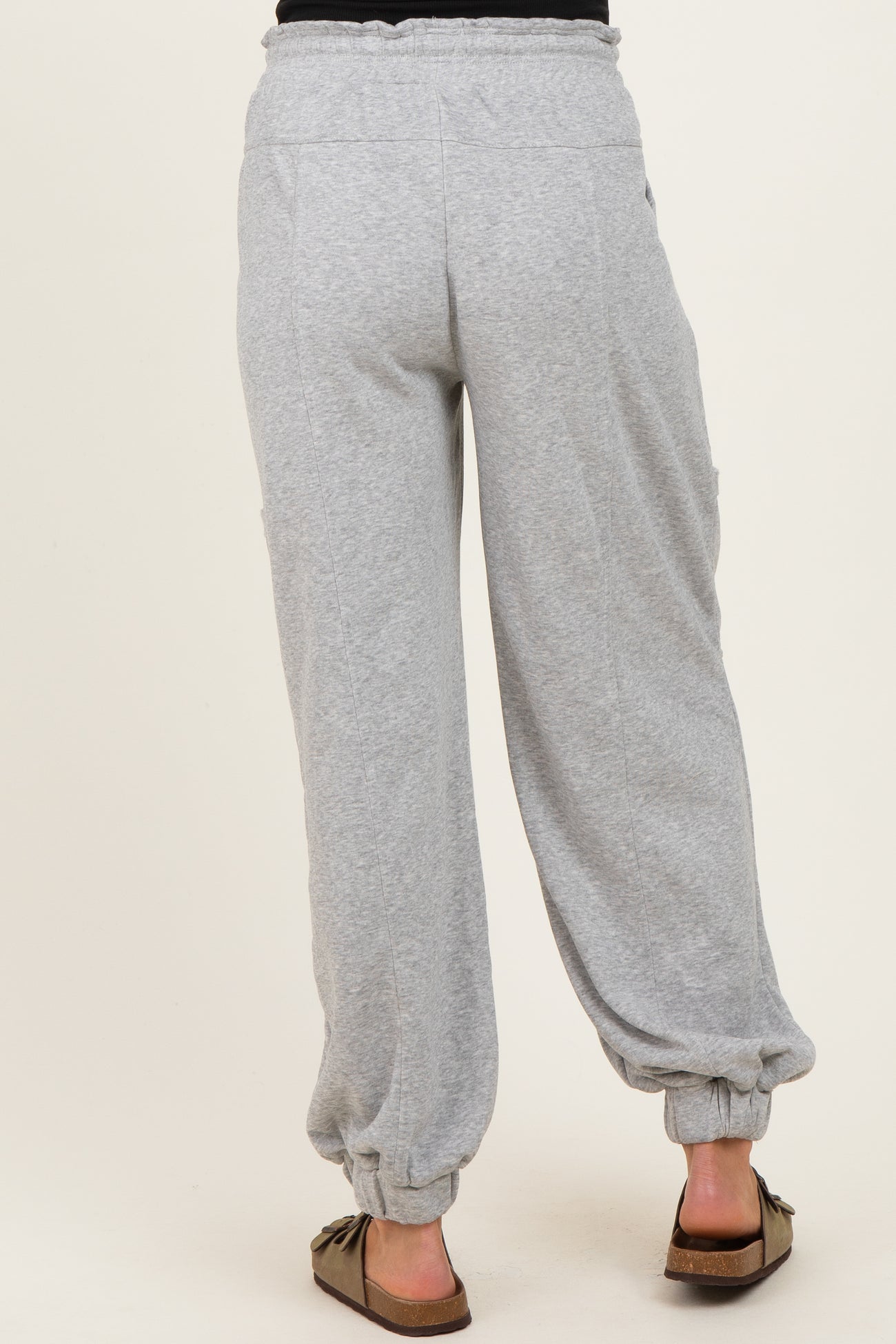woman wearing gray maternity pants with elastic cuffs and side pockets, shown from the back