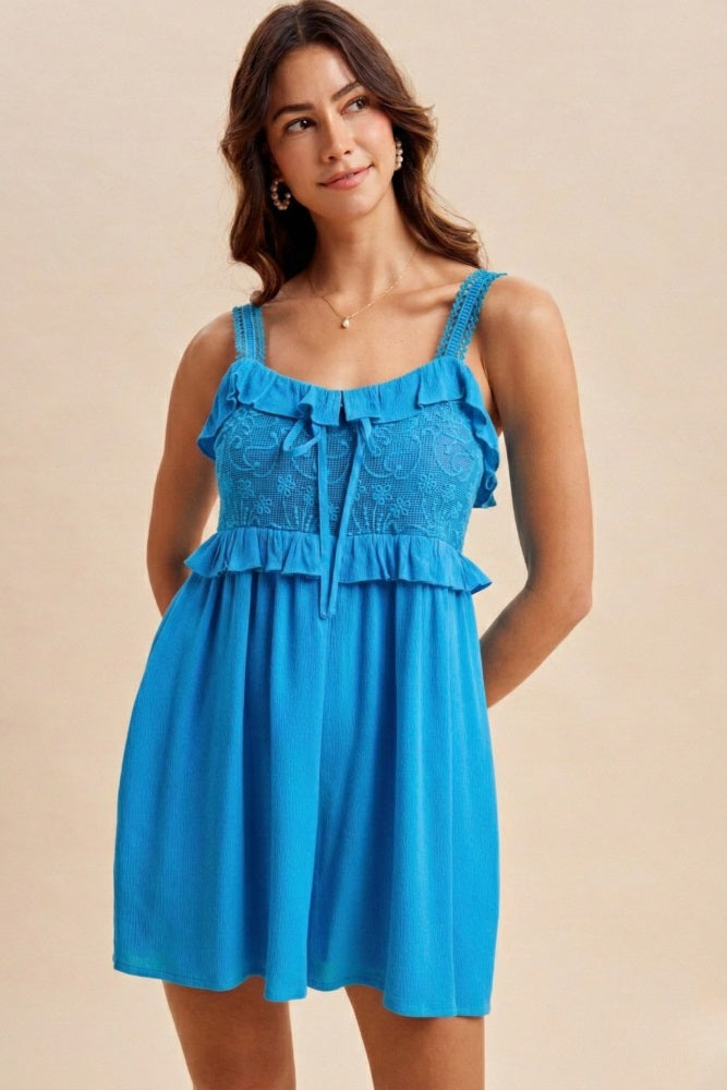 woman wearing a bright blue ruffled sundress with embroidered bodice and adjustable straps