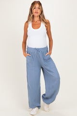 woman wearing a white tank top and light blue maternity wide-leg pants with pockets