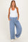 woman wearing a white tank top and light blue maternity wide-leg pants with pockets