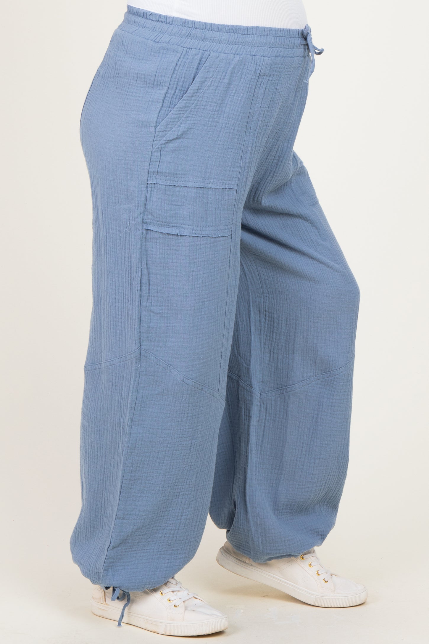 maternity wear light blue loose-fitting pants with a drawstring waist and side pockets, model showcasing baby bump