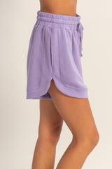 woman wearing a lavender shorts with an elastic waistband and side slits for added style