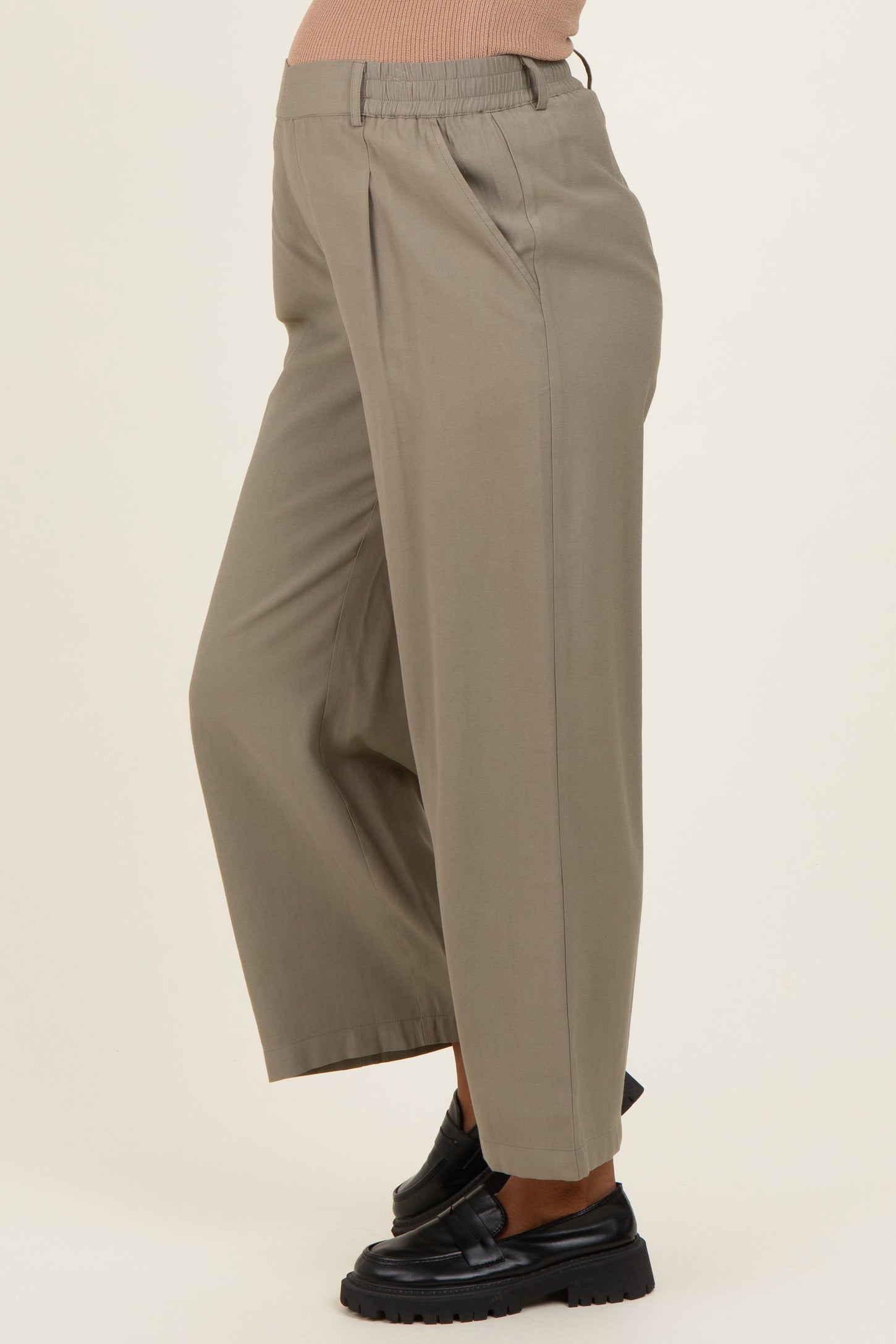 woman wearing light beige maternity wide-leg pants with an elastic waistband and side pockets