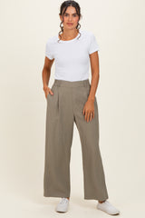 woman wearing a white short sleeve top and high-waisted khaki wide-leg pants with side pockets and white sneakers
