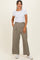 woman wearing a white short sleeve top and high-waisted khaki wide-leg pants with side pockets and white sneakers