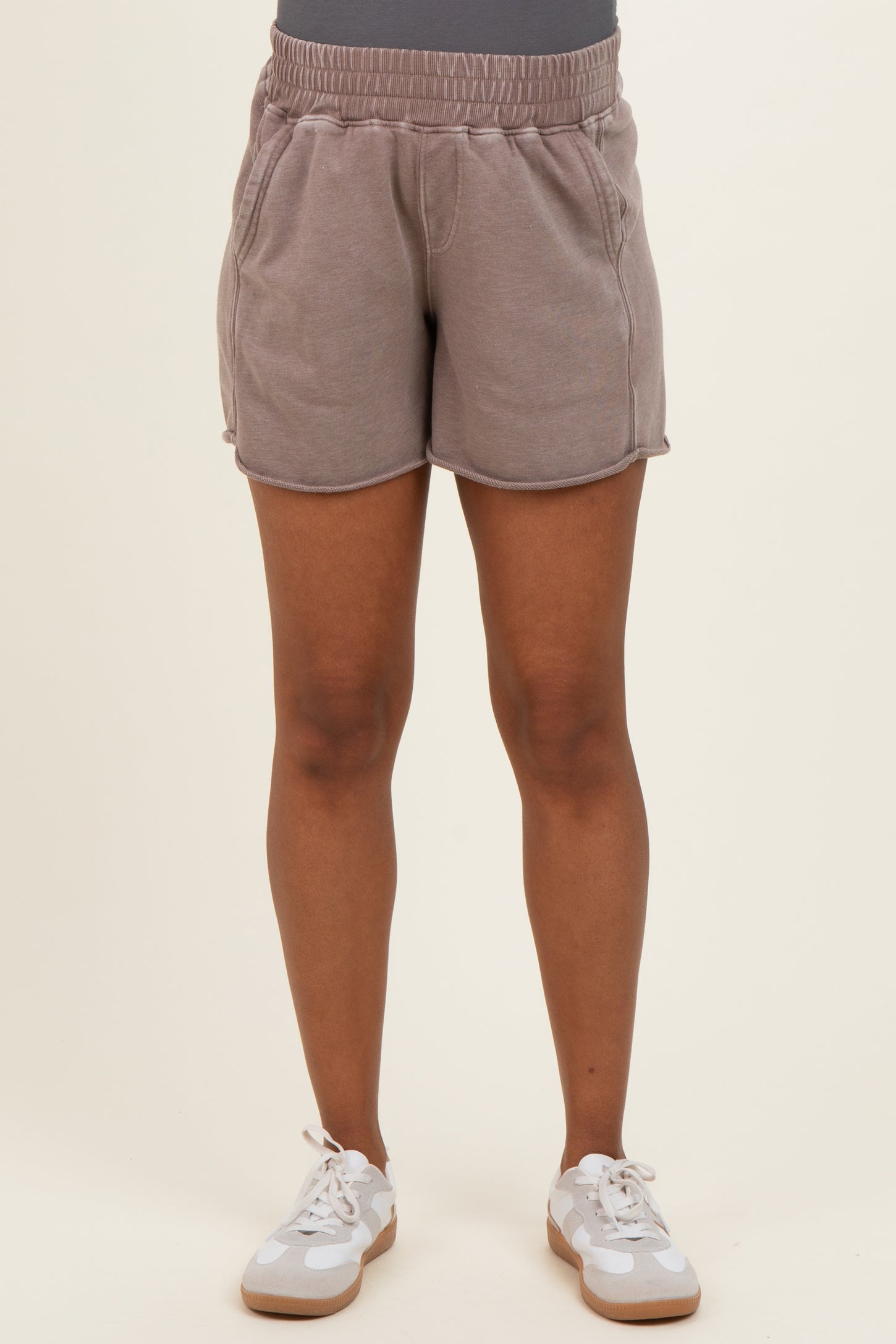 woman wearing light brown maternity shorts with an elastic waistband and side pockets