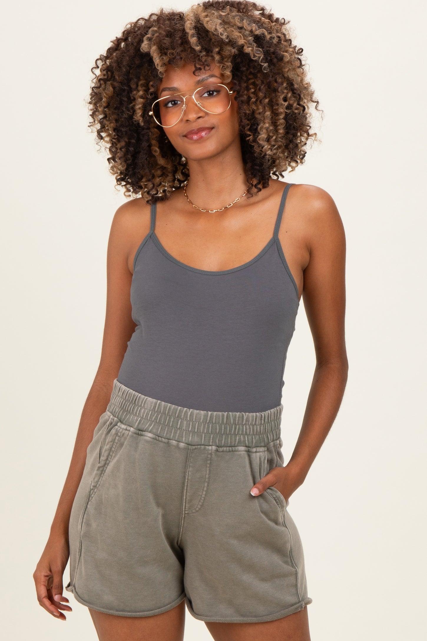 woman wearing a gray maternity tank top and olive green maternity shorts with an elastic waistband