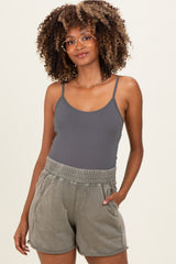 woman wearing a gray maternity tank top and olive green maternity shorts with an elastic waistband