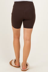 woman wearing brown maternity shorts, viewed from the back, with a smooth fit and pocket details