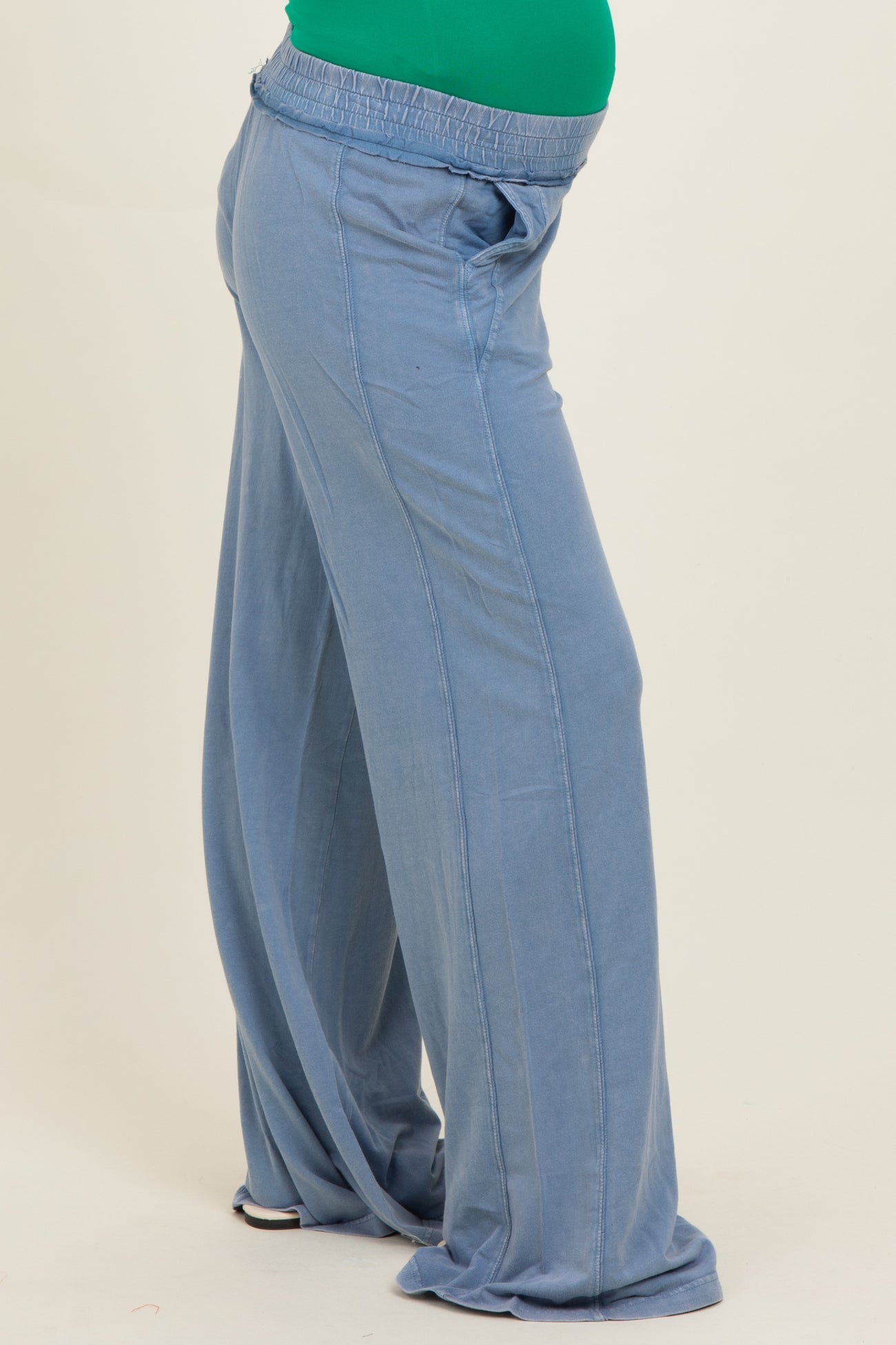 woman wearing soft blue maternity lounge pants with a side pocket and relaxed fit, highlighting a baby bump