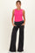 woman wearing a bright pink ribbed maternity tank top and black wide-leg maternity pants with pockets