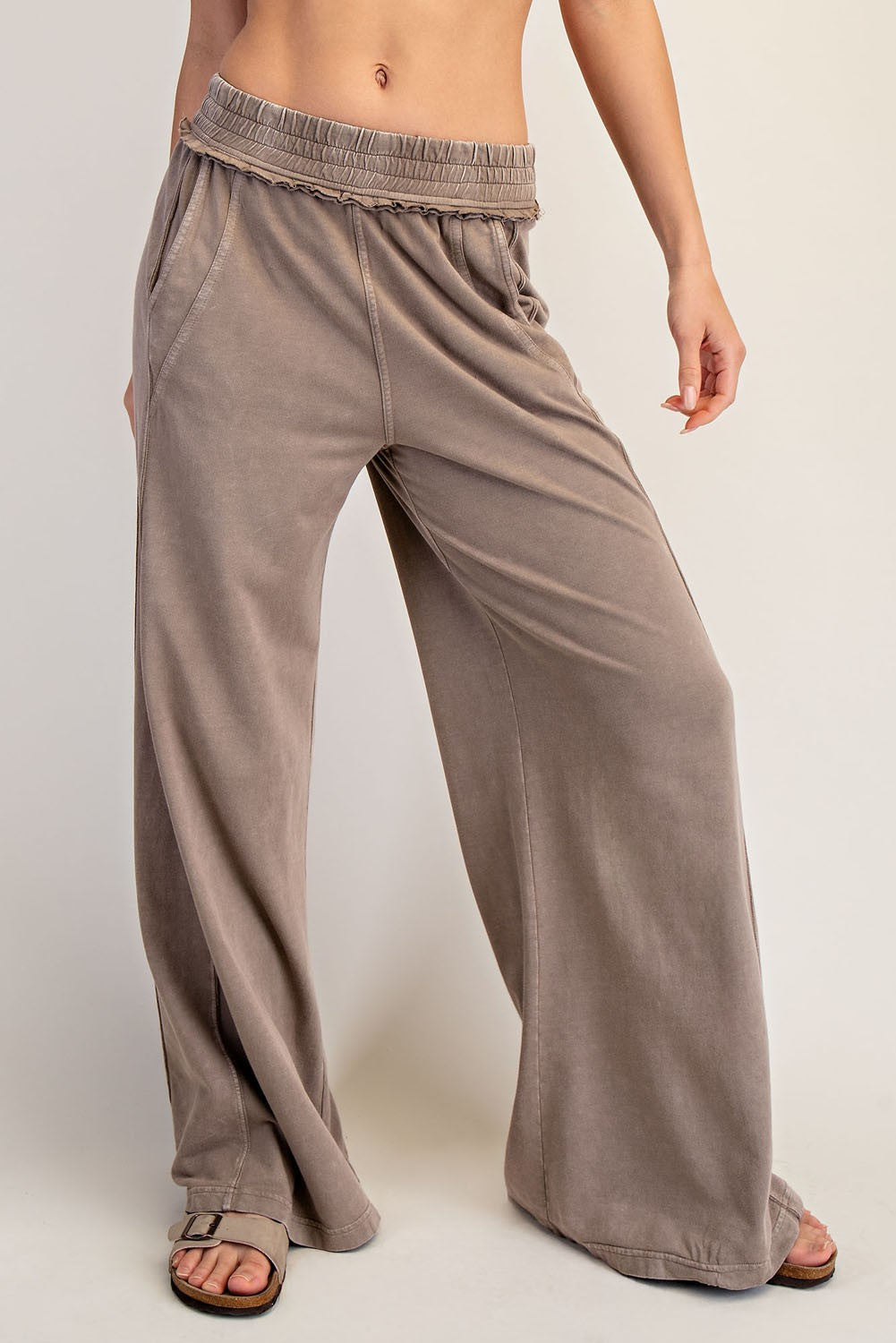 woman wearing taupe wide-leg lounge pants with an elastic waistband and side pockets