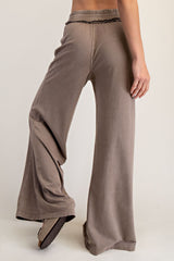 woman wearing taupe wide leg lounge pants with an elastic waistband and ruffle detail