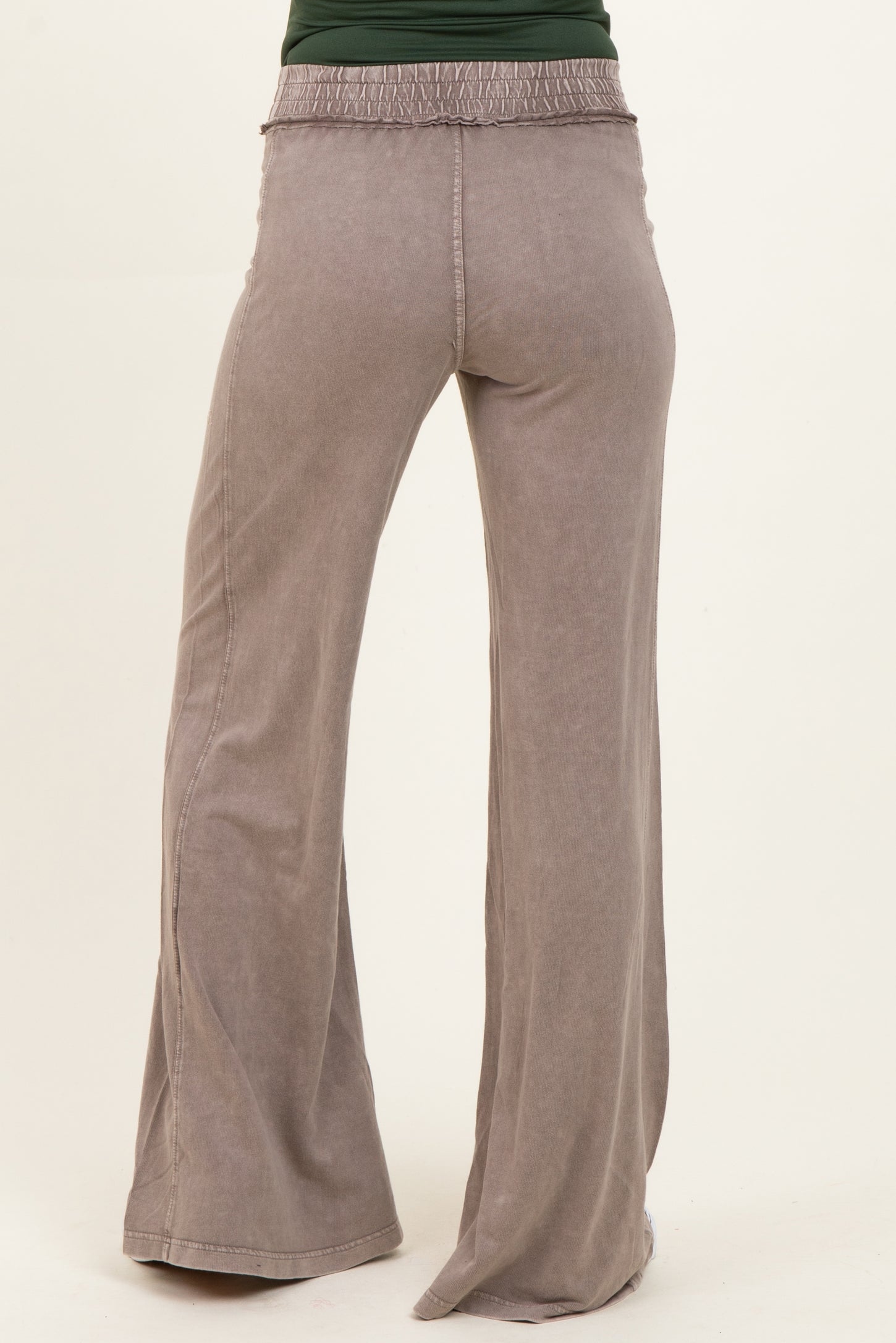 maternity wear light gray wide leg pants with smocked waist detail, model facing away from camera