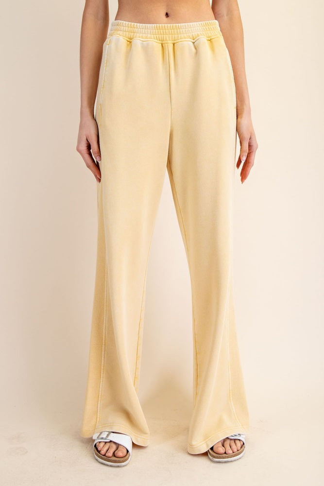woman wearing light yellow wide-leg lounge pants with an elastic waistband and side pockets