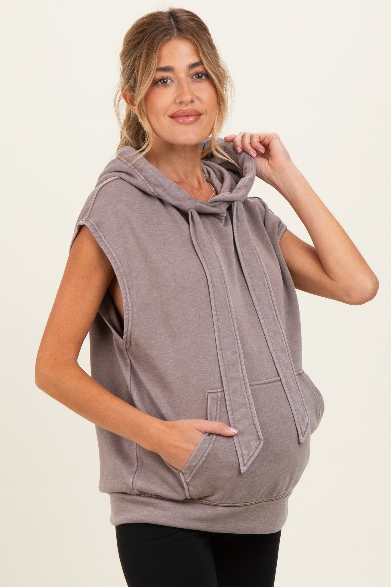 woman wearing a gray sleeveless maternity hoodie with a kangaroo pocket and a visible baby bump