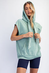 woman wearing a mint green sleeveless hoodie with a front pocket and drawstring, paired with navy blue bike shorts