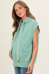 woman wearing a green sleeveless maternity hoodie with a front pocket and a visible baby bump