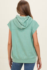 woman wearing a green sleeveless maternity hoodie with a hood, viewed from the back