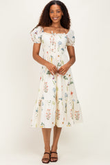 woman wearing a white floral midi dress with puff sleeves and a smocked bodice, standing with hands at her sides