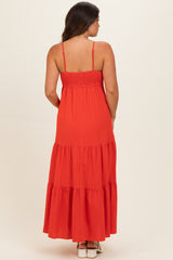 woman wearing a red maternity maxi dress with a smocked bodice and tiered skirt, seen from the back