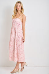 woman wearing a pink floral maxi dress with spaghetti straps and a tiered skirt