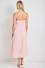 woman wearing a back view of a pink floral maxi dress with adjustable spaghetti straps and tiered skirt