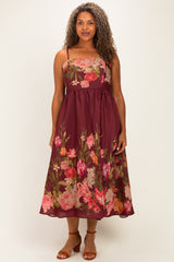 woman wearing a burgundy plus-size floral midi dress with spaghetti straps and a flowy skirt