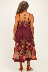 woman wearing a burgundy floral maxi dress with a smocked bodice and spaghetti straps, viewed from the back