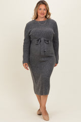woman wearing a dark gray ribbed maternity sweater dress with a tie waist and a visible baby bump