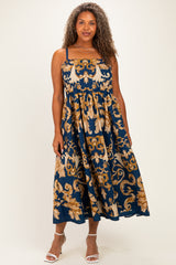 woman wearing a navy blue plus size maxi dress with gold floral patterns and spaghetti straps