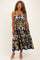 woman wearing a navy blue plus size maxi dress with gold floral patterns and spaghetti straps