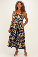 woman wearing a navy blue floral print plus size maxi dress with pockets and adjustable straps