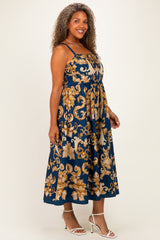 woman wearing a navy blue plus size maxi dress with gold floral prints and adjustable straps