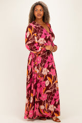 woman wearing a burgundy floral maxi dress with pink and orange flowers and long sleeves