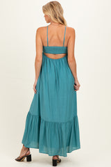 woman wearing a teal maternity maxi dress with a smocked back and tiered skirt, showing her baby bump