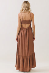 woman wearing a rust brown maxi dress with a smocked back and ruffled hem