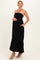 woman wearing a black strapless maternity maxi dress with a tiered hem and side pockets, showing her baby bump