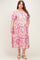 woman wearing a pink floral off-the-shoulder maxi dress, showcasing her baby bump, in maternity plus size