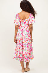 woman wearing a floral print midi dress with flutter sleeves and a square back, turning to show the back view