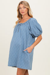 woman wearing a light blue maternity dress with puff sleeves and front pockets, showing her baby bump
