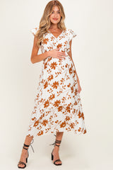 woman wearing a white floral maternity dress with short sleeves and a baby bump visible