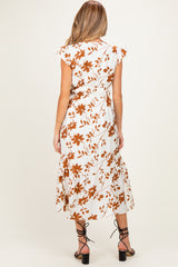 woman wearing a white maternity dress with brown floral print and flutter sleeves, showing the back view