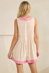 woman wearing a floral print sleeveless dress with a pleated back and pink trim