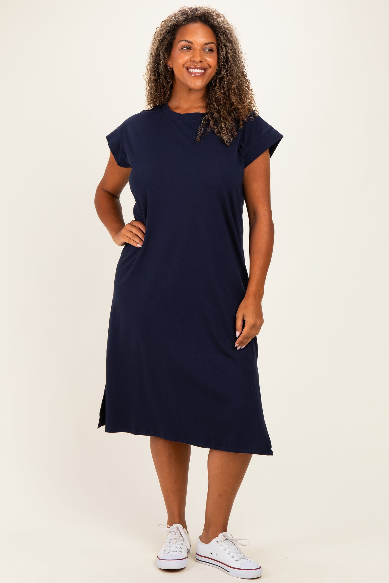 woman wearing a navy blue short sleeve midi dress with side slits and a relaxed fit