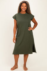 woman wearing an olive green plus size t-shirt dress with short sleeves and side slits, standing and smiling