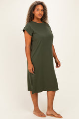 woman wearing a dark green short sleeve plus size dress with a relaxed fit and side slits, standing sideways in sandals